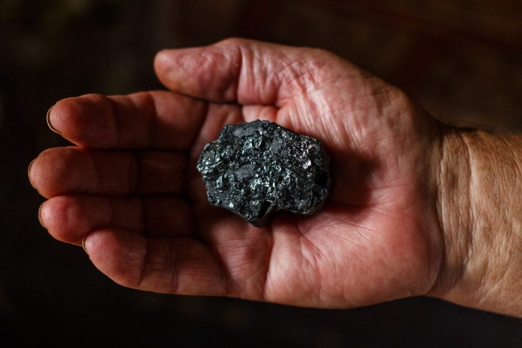 A lump of coal in a person's hand